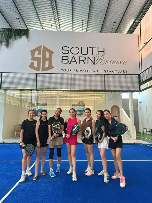 A group of women with rackets in front of the Reserve sign